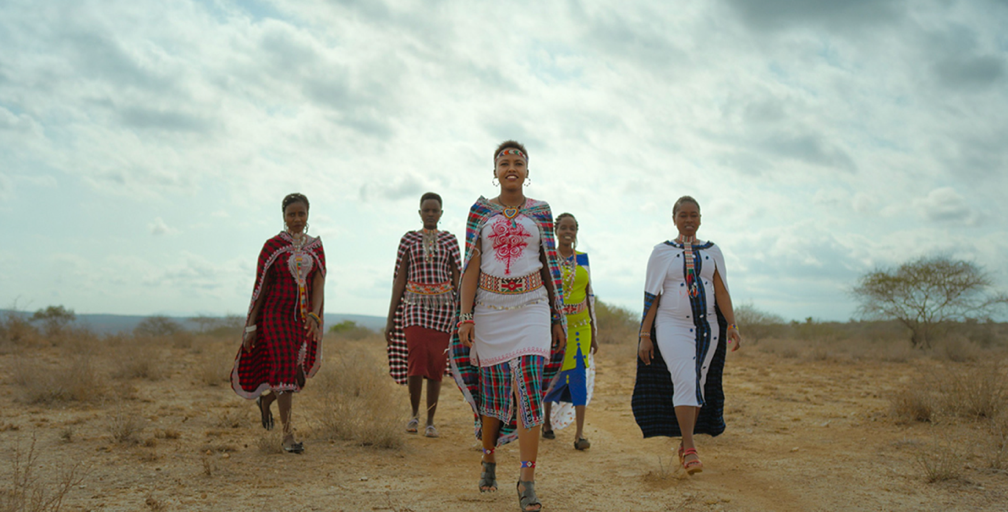A group of women walking in a fieldDescription automatically generated